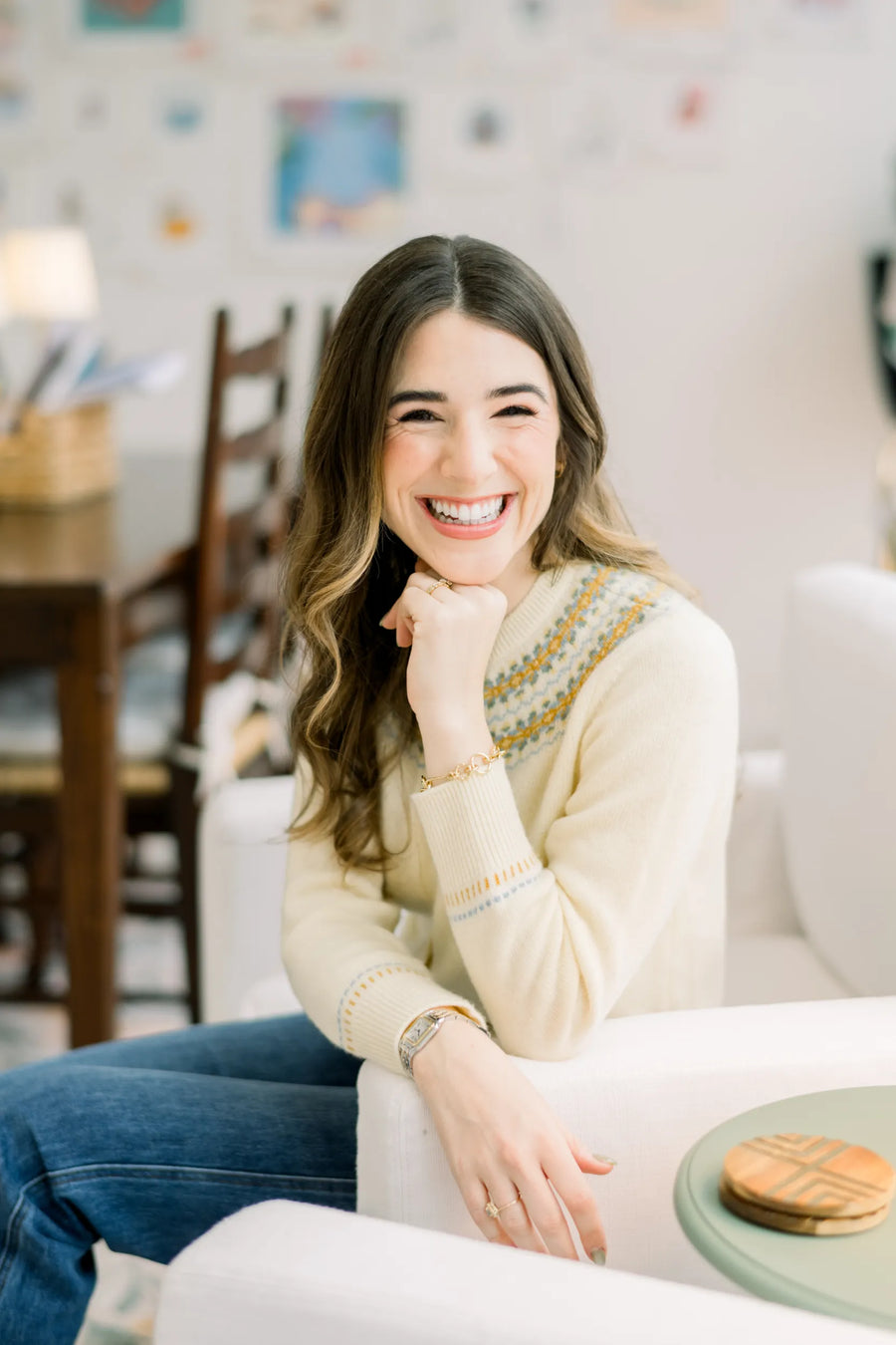 Abbie Lilly, founder of Dogwood Needlepoint, smiling in her home studio